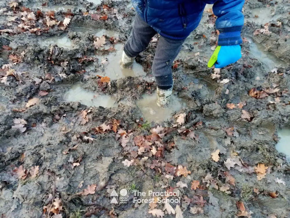 Child wearing wellies stuck in the mud