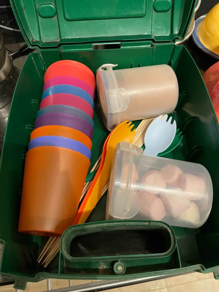 Hot chocolate powder, marshmallows and cups in a green plastic box